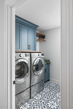 a washer and dryer in a laundry room with blue cabinets on the wall