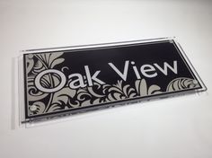 an oak view sign hanging from the side of a wall in front of a white wall