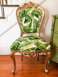 a green chair sitting on top of a hard wood floor next to a stair case