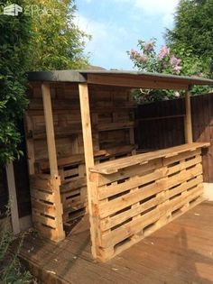 an outdoor bar made out of pallets and wooden planks on a deck outside