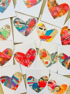 many different colored hearts are displayed on white cards and envelopes that have been folded together