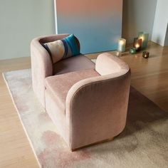 a living room with a couch, rug and candles on the floor in front of it