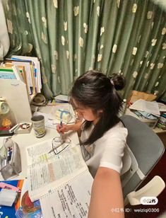 a woman sitting at a desk with papers and pens