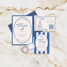 the wedding stationery is laid out on top of the marble countertop, and features blue trimmings