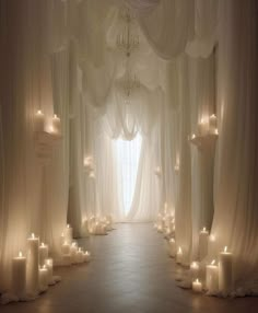 a white wedding ceremony with candles and drapes