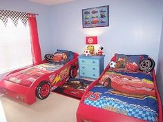 two children's beds with cars on them in a bedroom