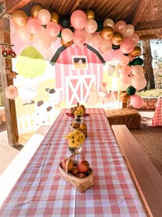 a table with some fruit on it and balloons hanging from the ceiling in the background