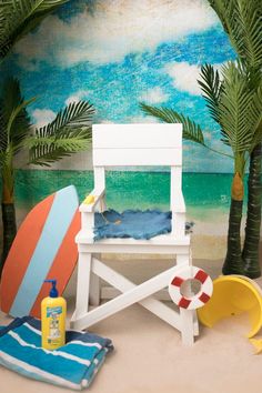 a white chair sitting on top of a sandy beach next to palm trees and a life preserver