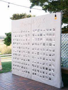 an outdoor seating area is decorated with photos and string lights