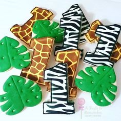 decorated cookies in the shape of giraffes, palm leaves and zebra stripes