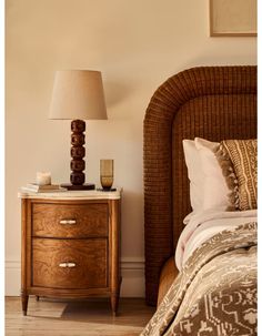 a bedroom with a wicker headboard and night stand