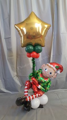 an inflatable balloon is attached to a christmas decoration with a boy sitting on the ground