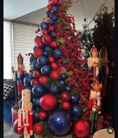 a christmas tree decorated with red, white and blue ornaments next to other holiday decorations