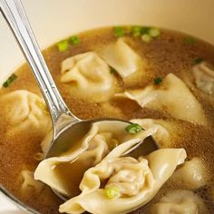 a close up of a bowl of soup with dumplings