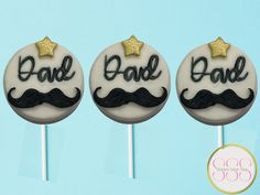 three decorated cake pops with the words dad and mustaches on them