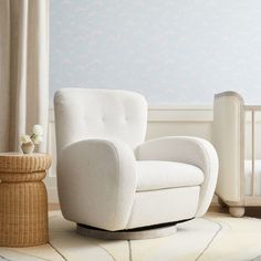 a white rocking chair next to a baby crib