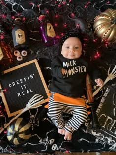 a baby dressed up as a skeleton sitting in front of halloween decorations