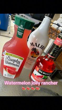 three bottles of liquid sitting on top of a counter