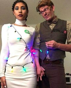 two people standing next to each other with christmas lights on their body and one person wearing glasses