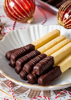 several pieces of chocolate on a plate with candy canes and christmas decorations in the background