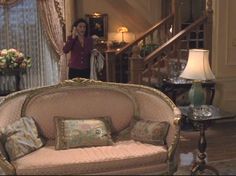 a woman standing in front of a fancy couch