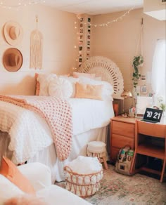 a bedroom decorated in pink and white with lots of pillows on the bed, lights strung over the headboard