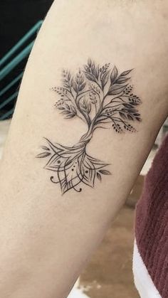 a woman's arm with a tree tattoo on it