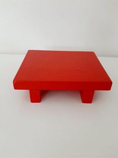 a red table sitting on top of a white floor