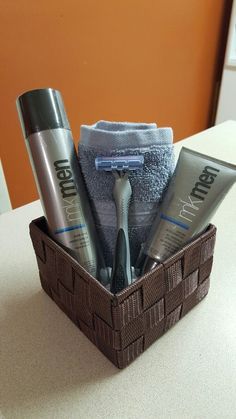 a brown basket filled with personal care items on top of a white counter next to a blue towel