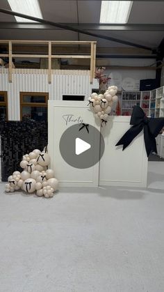 balloons are arranged on the floor in front of an open door with a black ribbon