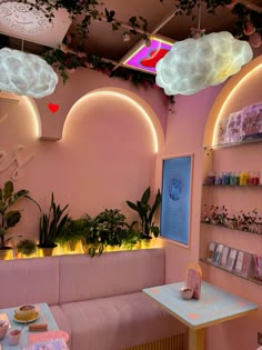 the interior of a restaurant with pink walls and white clouds hanging from the ceiling above