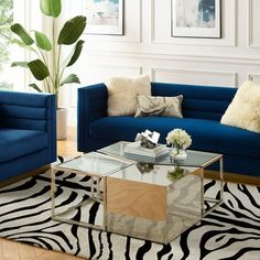 a living room with zebra print rug and blue couches