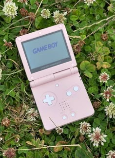 a pink game boy sitting in the grass