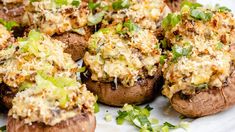 a white plate topped with stuffed mushrooms covered in toppings