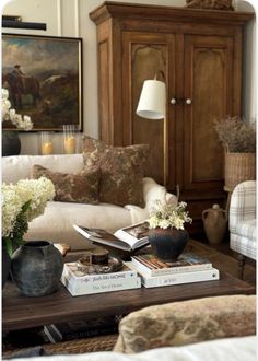 a living room filled with lots of furniture and books on top of a coffee table