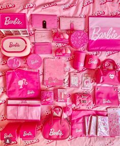 pink barbie doll accessories are laid out on a bed sheet with the name barbie written on it