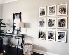 a living room with pictures on the wall and a table in front of it next to a lamp