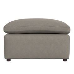 a grey ottoman with two pillows on it