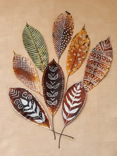 several different colored leaves on a brown surface