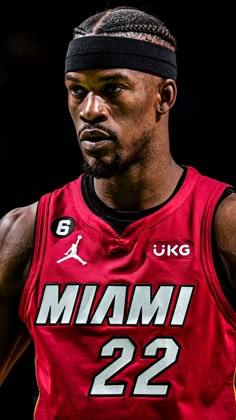 the basketball player is wearing a red jersey and black headband with his name on it