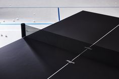 the ping pong table is black and has white lines on it, as well as an arrow