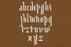 an old fashioned handwritten font in white ink on brown paper with the letters and numbers below