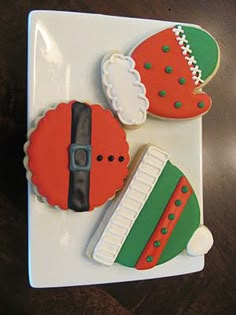 three decorated cookies sitting on top of a white plate