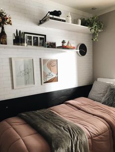 a bed sitting in a bedroom next to a wall with pictures hanging on the walls