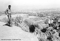 a man standing on top of a cliff next to a city