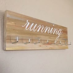 a wooden sign that says running hanging on the wall