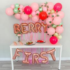 there is a table with balloons and some food on it