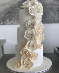 a three tiered white wedding cake with flowers on top