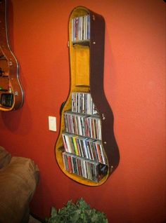 a guitar shaped book shelf is mounted to the wall