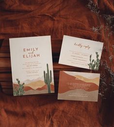 two wedding stationery cards on a bed with brown linens and desert themed paper